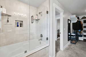 Bathroom featuring baseboards, tile patterned flooring, and tiled shower / bath combo