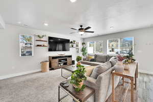 Living area with ceiling fan, baseboards, visible vents, and a wealth of natural light