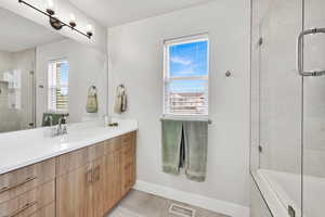 Full bath featuring visible vents, tile patterned floors, baseboards, vanity, and tiled shower / bath
