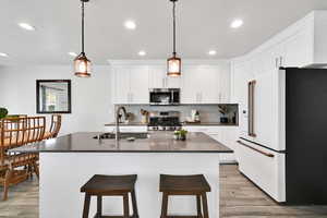 Kitchen featuring a sink, appliances with stainless steel finishes, recessed lighting, and dark countertops