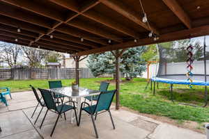 View of patio / terrace with a fenced backyard, outdoor dining space, and a trampoline