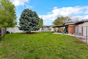 View of yard with a fenced backyard, a trampoline, and a patio area