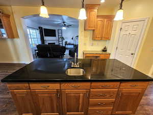 Kitchen island with handy prep sink looking into the family through high arch opening