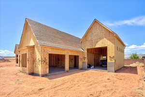 Rear view of property featuring fence and a detached garage