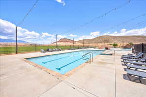 Pool featuring fence, a mountain view, and a patio
