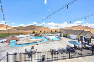 Pool featuring fence, a mountain view, a jacuzzi, and a patio