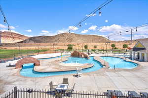 Pool with fence, a mountain view, and a patio