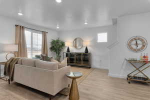 Living area featuring baseboards, light wood-style flooring, and a wealth of natural light