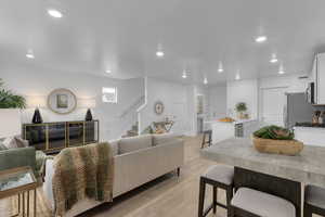 Living area featuring recessed lighting, stairs, and light wood-style floors