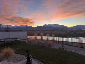 Yard at dusk with a mountain view and a trampoline