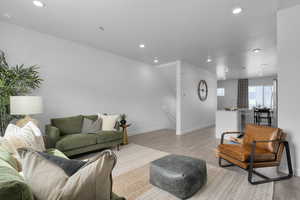Living room featuring light wood-style floors, baseboards, and recessed lighting