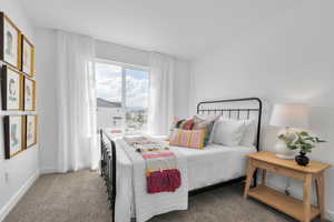 Bedroom with light colored carpet and baseboards