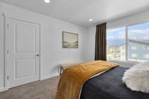 Carpeted bedroom featuring baseboards, recessed lighting, and a mountain view