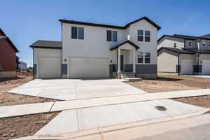 View of front of house featuring concrete driveway, a garage, and board and batten siding