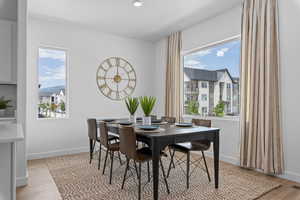 Dining space featuring light wood-type flooring, baseboards, and visible vents