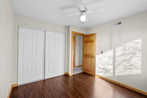 Unfurnished bedroom featuring dark wood finished floors, ceiling fan, and a closet