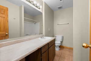 Bathroom with a shower, light tile patterned floors, and vanity