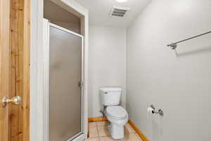 Full bathroom with tile patterned floors and a shower stall