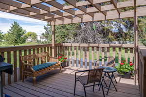 Deck featuring a pergola with Greenspace Behind