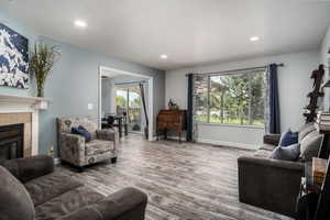 Living area featuring recessed lighting, LVP floors, and a fireplace