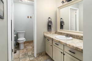 Master Bathroom with vanity, stone finish flooring, Shower / Bathtub combination and toilet