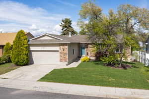 Ranch-style home with fence, a front lawn, brick siding, a garage, and concrete driveway