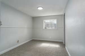 Carpeted empty room featuring baseboards