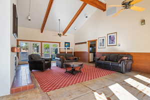 Living room featuring ceiling fan, visible vents, beam ceiling, track lighting, and high vaulted ceiling