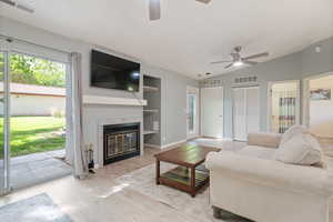 Living room featuring a ceiling fan, a textured ceiling, and visible vents