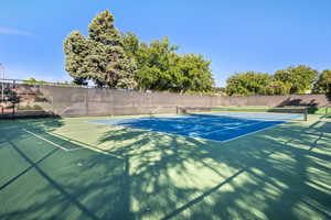 View of tennis court featuring fence