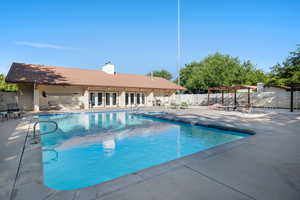 Community pool with french doors, fence, a pergola, and a patio area