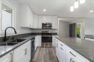 KITCHEN WITH STAINLESS STEEL APPLIANCES AND QUARTZ COUNTER TOPS