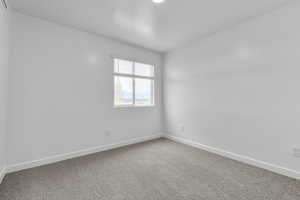 Empty room with carpet flooring and baseboards