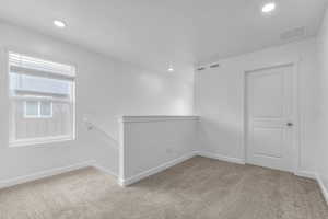 Empty room with baseboards, recessed lighting, visible vents, and carpet