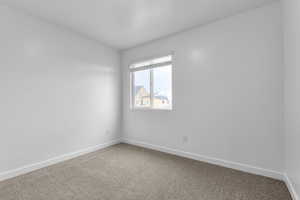 Spare room with baseboards and carpet