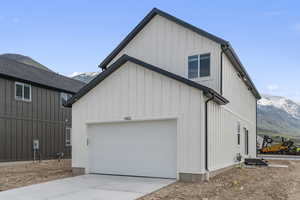 View of home's exterior with concrete driveway, a mountain view, a garage, and board and batten siding