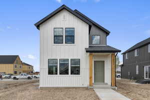 Modern farmhouse featuring roof with shingles and board and batten siding