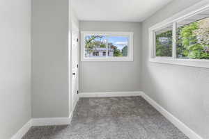 Spare room featuring carpet floors and baseboards