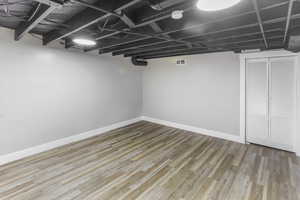 Finished below grade area with baseboards, wood finished floors, and visible vents