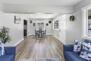Living area featuring light wood-style floors, baseboards, recessed lighting, and visible vents
