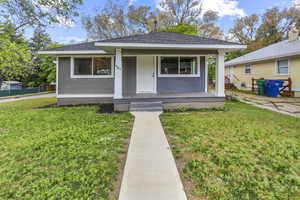 Bungalow-style home featuring a porch, roof with shingles, and a front lawn
