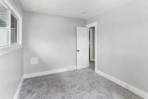 Empty room with baseboards, carpet flooring, and visible vents