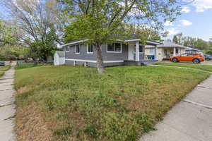 View of front of home featuring covered porch and a front lawn