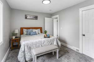 Bedroom with carpet floors, baseboards, and visible vents