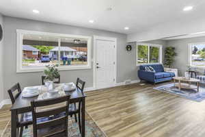 Dining room with visible vents, baseboards, plenty of natural light, and wood finished floors