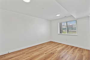 Unfurnished room with light wood-style floors, baseboards, and visible vents