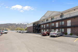 View of building exterior featuring a mountain view and uncovered parking