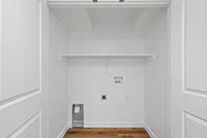Washroom featuring electric dryer hookup, hookup for a washing machine, baseboards, and wood finished floors