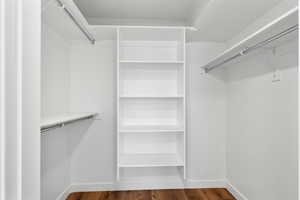 Walk in closet with wood finished floors