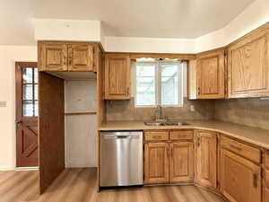Kitchen with plenty of natural light, a sink, light wood finished floors, and dishwasher